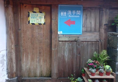 a wooden door with a sign on it at Matsu 1st Hostel in Nangan