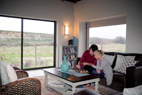 two people sitting on a couch in a living room at De Old Drift Guest Farm in Addo