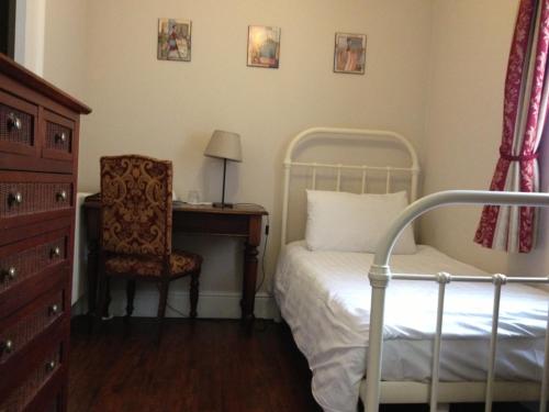 1 dormitorio con cama, escritorio y silla en Balham Lodge en Londres