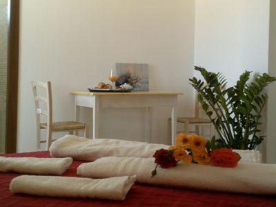 una mesa con almohadas y flores encima en La casa di Giovanni e Angela, en Alghero