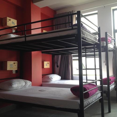 two bunk beds in a room with red walls at Bondi Backpackers Nhatrang in Nha Trang