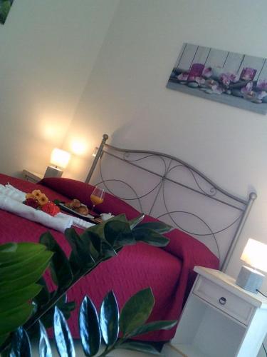 1 dormitorio con cama roja y sofá rojo en La casa di Giovanni e Angela, en Alghero