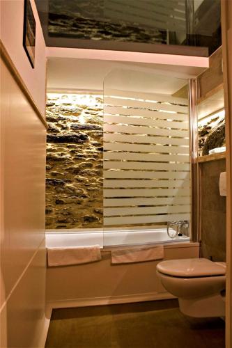 a bathroom with a toilet and a window with a painting at Casa Berdeal in Mañón