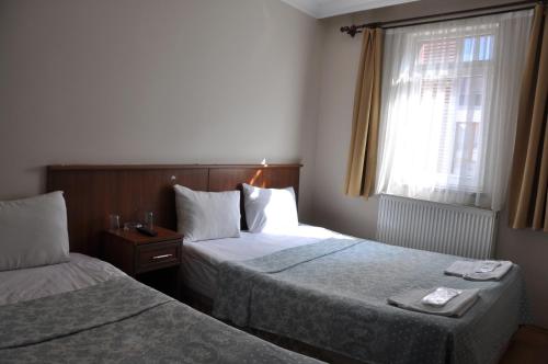 a hotel room with two beds and a window at Hekimoğlu Hotel in Erzurum