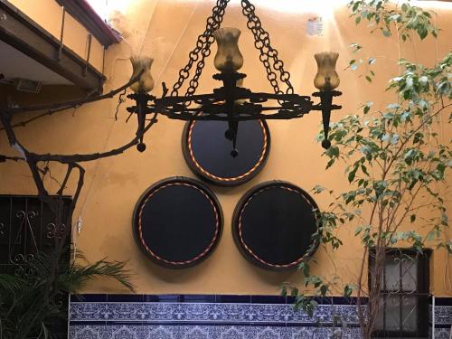 a chandelier hanging from a wall with three round mirrors at Hotel Nova Centro in Jerez de la Frontera