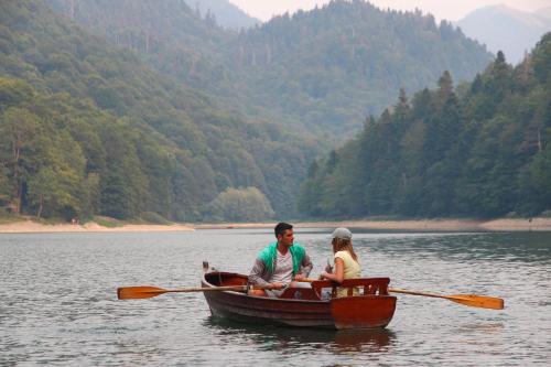 a man and woman in a boat on a lake at Hotel & Resort Gacka in Mojkovac