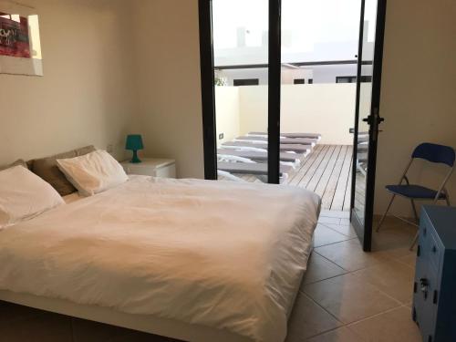 sypialnia z białym łóżkiem i balkonem w obiekcie Buganvilla 19 forever w mieście Playa Blanca