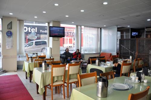 エルズルムにあるHekimoğlu Hotelのテーブルと椅子、座り込みのレストランを併設しています。
