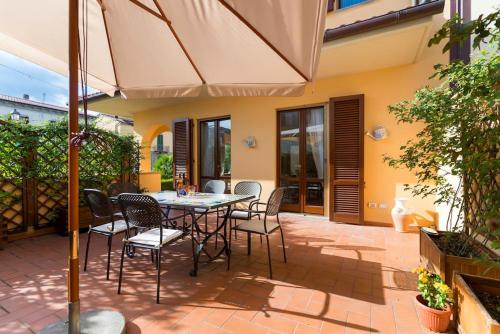 a patio with a table and chairs and an umbrella at Hidden Tuscan Treasure in Cantagrillo