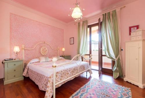 ein rosafarbenes Schlafzimmer mit einem Bett und einem Fenster in der Unterkunft Hidden Tuscan Treasure in Cantagrillo