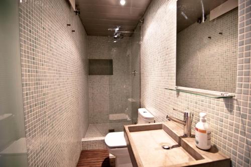 W łazience znajduje się umywalka, toaleta i lustro. w obiekcie Barceloneta Suites Apartments Beach w Barcelonie