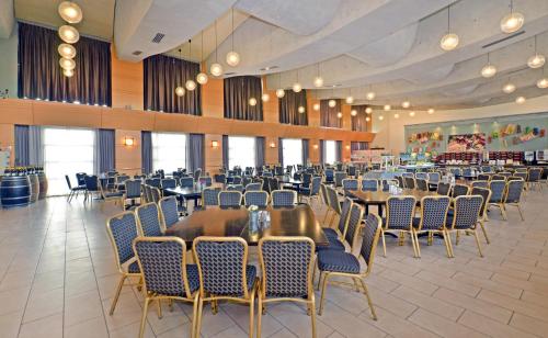 a restaurant with tables and chairs in a room at Ruth Daniel Residence in Tel Aviv