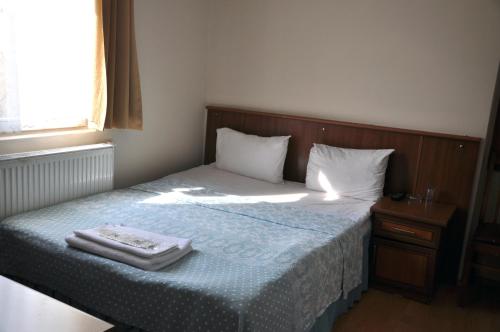 a bedroom with a bed with a wooden head board at Hekimoğlu Hotel in Erzurum