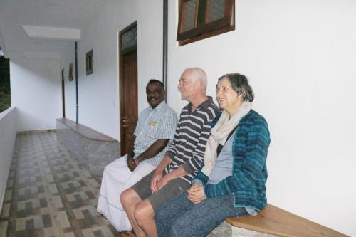 a group of three people sitting on a bench at Queens rest inn in Haputale