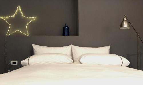 a bedroom with a white bed with a star on the wall at charming new loft in Bologna