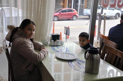 a woman sitting at a table with a boy at a table at Hekimoğlu Hotel in Erzurum