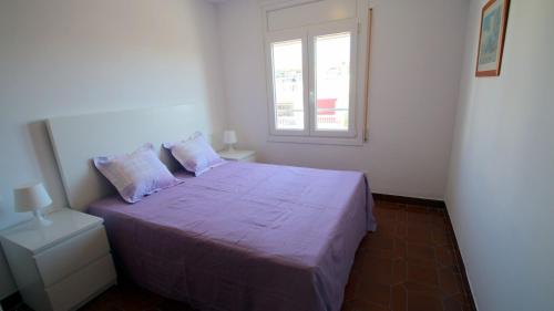 カンブリルスにあるApartamento Leoのベッドルーム(紫色のベッド1台、窓付)