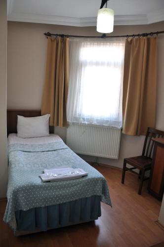 a bedroom with a bed and a window at Hekimoğlu Hotel in Erzurum