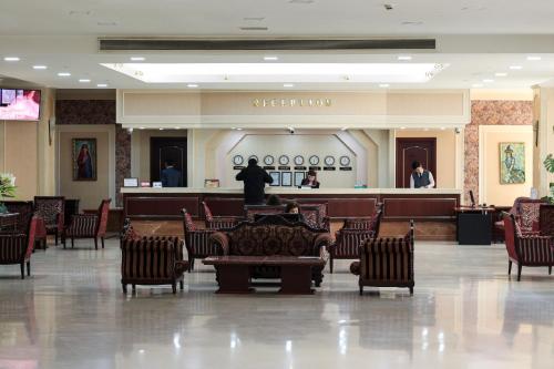 een lobby met stoelen en een wachtruimte in een gebouw bij Hotel Uzbekistan in Tasjkent