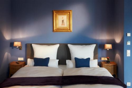 a bedroom with blue walls and a bed with two pillows at Auberge de Temple in Johannesberg