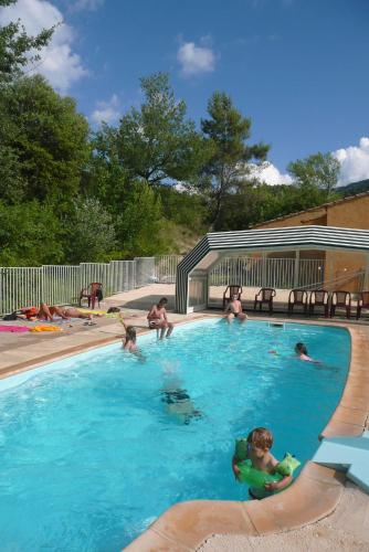 un groupe de personnes dans une piscine dans l'établissement Domaine de bois joli, à Buis-les-Baronnies