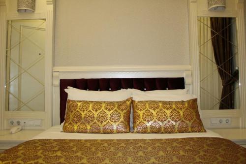 a bed with a white comforter and pillows at Hotel Coliseum in Istanbul