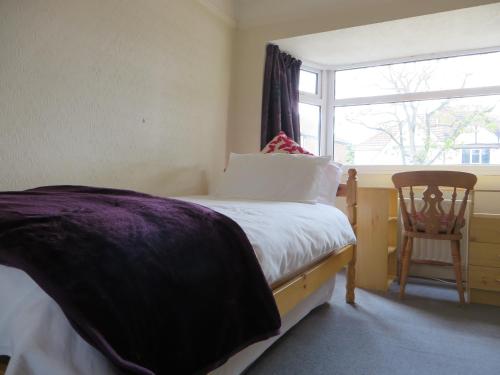 a bedroom with a bed and a window and a chair at Comfortable rooms in Birmingham