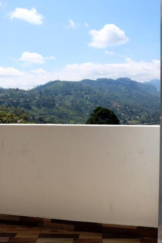 a white wall with a view of a mountain at Queens rest inn in Haputale