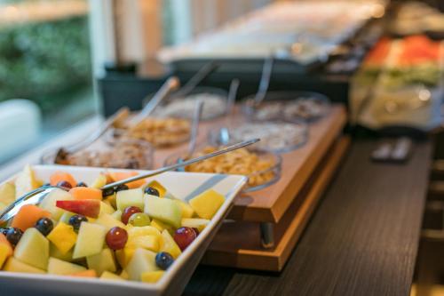 a buffet with a plate of fruit on a table at Hotel Zeerust Texel in De Koog