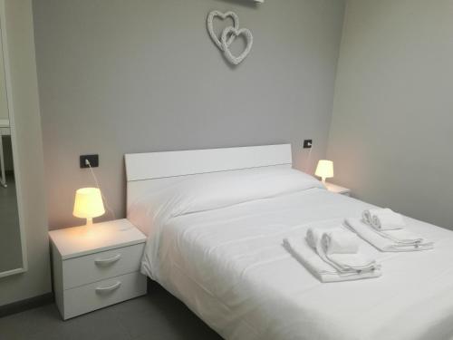 a white bedroom with a white bed with a heart on it at Lingotto Residence in Turin
