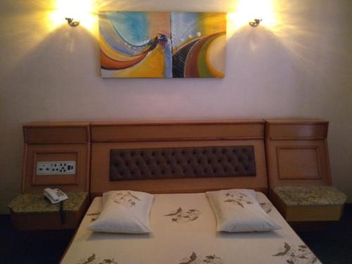 1 dormitorio con 1 cama con 2 almohadas y una pintura en Hotel Jardim América ( Adults only), en São Paulo