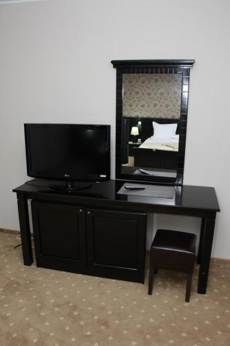 a black desk with a television and a mirror at Hotel Imperium in Suceava