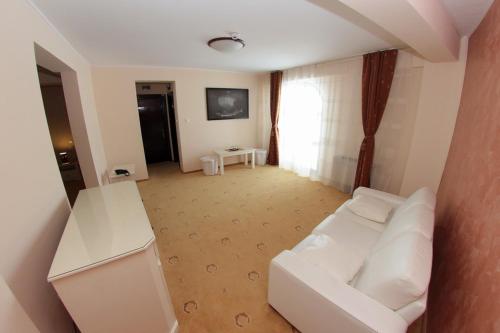 a living room with a white couch and a table at Hotel Imperium in Suceava