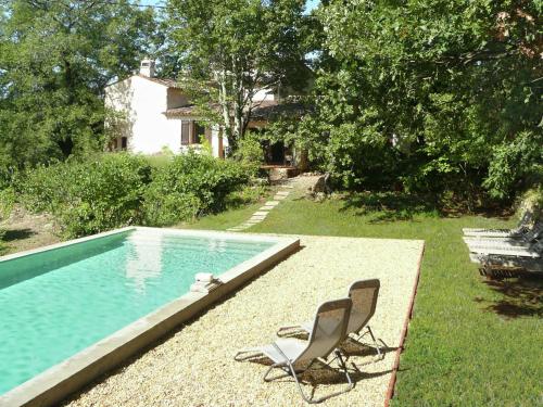 una silla sentada junto a una piscina en Beautiful riverside villa in Entrecasteaux, en Entrecasteaux