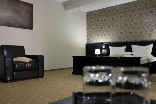 a hotel room with a bed and a couch at Hotel Imperium in Suceava