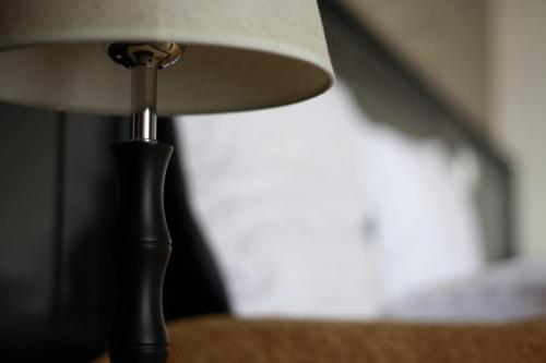 a black lamp with a white shade on a table at Hotel Imperium in Suceava