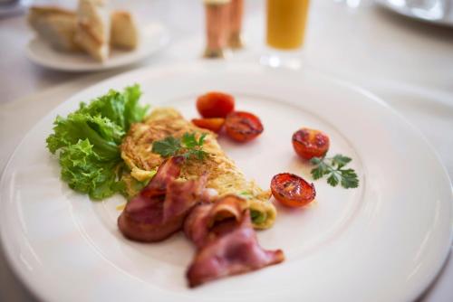 a plate of food with bacon and vegetables on a table at Orient Palace in Bielany Wrocławskie