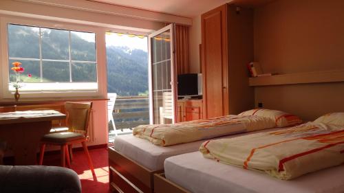 a hotel room with two beds and a window at Ferienwohnung Vier Jahreszeiten in Hirschegg