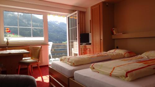 Habitación de hotel con 2 camas y ventana en Ferienwohnung Vier Jahreszeiten, en Hirschegg