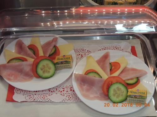 two plates of food with tomatoes and cucumbers on them at AVIA Motel Bisamberg in Korneuburg