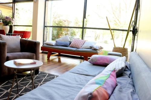 a living room with couches and a large window at La Résidence du Spa et la Résidence des Thermes in Meyras