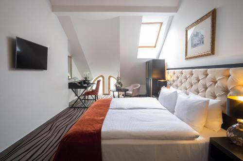 a hotel room with a large bed and a television at Boutique Hotel Slávia in Košice