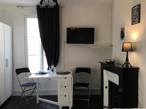 ニオールにあるLe Romantic centre 400m gare wifi linge de pressingの白いテーブルと椅子、窓が備わる客室です。