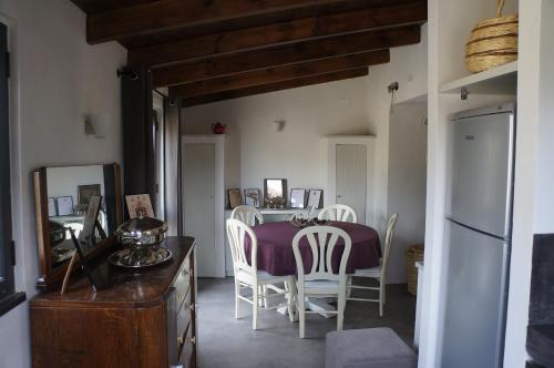 a dining room with a table and white chairs at Les Villas de Qeparo in Qeparo
