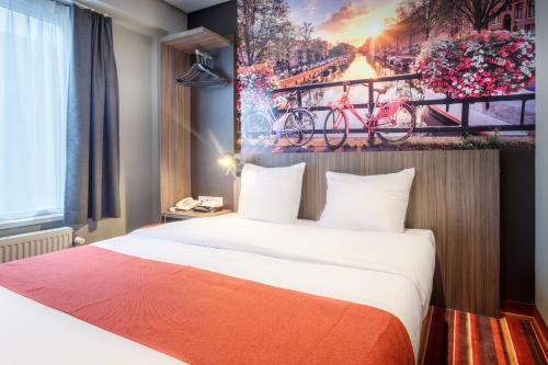 una camera d'albergo con un letto e un dipinto sul muro di Mozart Hotel ad Amsterdam