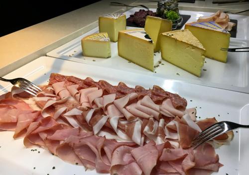 a plate of food with meat and cheese on a table at Grischa - Das Hotel Davos in Davos