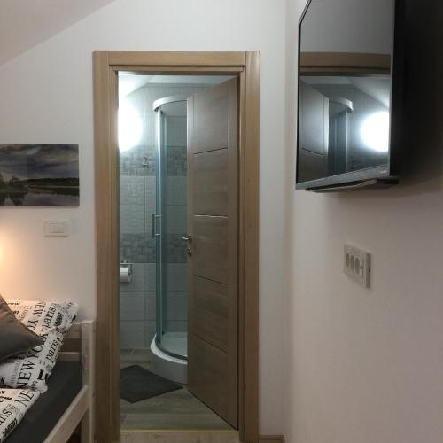a bathroom with a shower and a glass door at Sobe-Rooms Kvatric in Zagreb