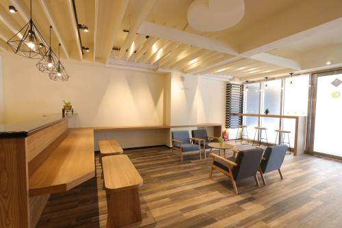 a waiting room with tables and chairs and windows at Flora Inn in Tainan