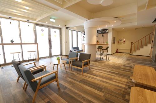 a large room with chairs and tables and windows at Flora Inn in Anping