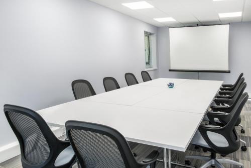 a conference room with a white table and chairs at De Vere Latimer Estate in Chesham